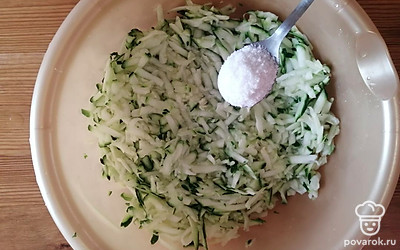 Кабачок хорошо помойте и натрите на крупной терке. Добавьте соль и хорошо перемешайте. 