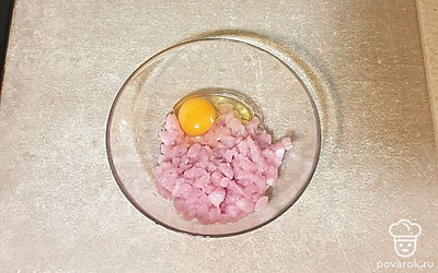 В миску выложите нарезанное филе, добавьте яйцо.