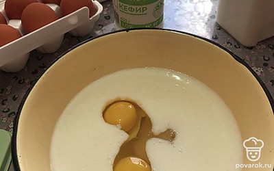 В кефир комнатной температуры вбейте 2 яйца, добавьте 80 граммов сахара.