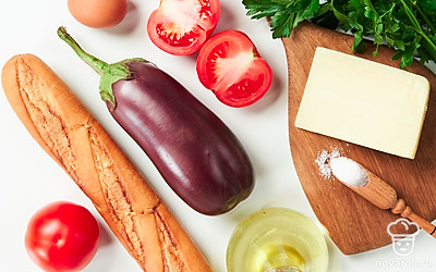 Баклажан помойте и нарежьте на круглые дольки 0,5 см толщиной. Багет нарежьте толщиной 1 см. Зелень петрушки ополосните, обсушите и мелко порубите. Отложите немного зелени для подачи. Помидоры помойте и нарежьте кружками примерно 0,5 см толщиной. Помойте яйцо. Сыр нарежьте тонкими ломтиками. Разогрейте духовку до 180 градусов и смажьте противень растительным маслом.
