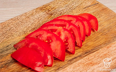 Помидор разрежьте пополам и нарежьте тонкими пластинками.