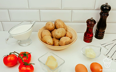 Помойте и очистите картофель. Помойте помидоры и яйцо. Включите духовку разогреваться до 180 °C.