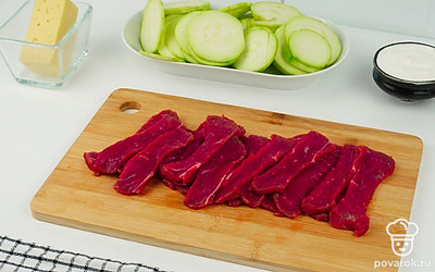 Кабачки и лук нарежьте тонкими кольцами. Говядину нарежьте небольшим кубиком. Сыр натрите на крупной терке.