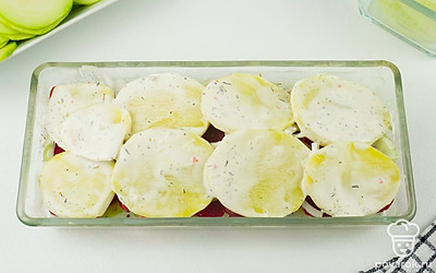 Поставьте форму в духовку на 70 минут при 200 °С. Затем достаньте форму из духовки, присыпьте блюдо тертым сыром и верните в духовку еще на 10 минут.