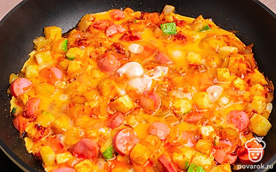 Разбейте куриные яйца и залейте ими кабачки с сосиской. Посолите блюдо по вкусу.