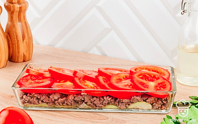 Помидоры нарежьте колечками, сыр натрите на крупной терке. Возьмите стеклянную форму для запекания и выложите в нее слоями все необходимые ингредиенты в следующей последовательности: кабачки, фарш, помидоры.