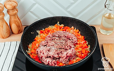 Возьмите глубокую сковороду, смажьте ее растительным маслом и положите в нее нарезанный репчатый лук, чеснок, морковь, фарш и специи.