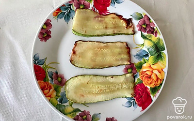 Кабачки разрежьте вдоль на тонкие пластины. Обжарьте их на оливковом масле до золотистого цвета. Немного остудите.