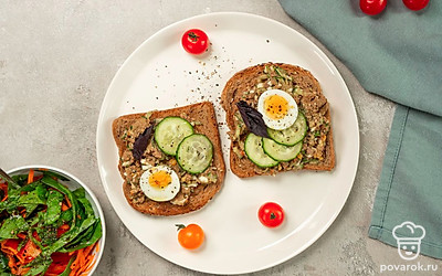 Украсьте тосты с говяжьей печенью веточками укропа и петрушки. В центр тарелки с бутербродами положите оставшиеся половинки вареного белка и выложите в них остатки готовой начинки.