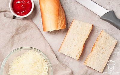 Подготовьте багет. Разделите багет пополам. Каждую половину разрежьте вдоль на две части.