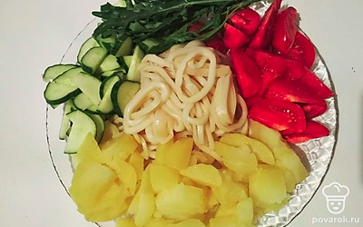 Нарежьте отварной картофель небольшими брусочками, помидоры и огурцы – крупными дольками. Рукколу и другую зелень хорошо промойте и мелко нарежьте.