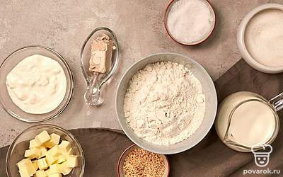 Заранее подогрейте воду, чтобы она стала теплой, но не горячей. Из инструментов возьмите миску, в которой будете смешивать ингредиенты, противень, пищевую пленку и пергаментную бумагу. Заранее разогрейте духовку до 200 градусов и застелите противень пергаментной бумагой. Сливочное масло доведите до комнатной температуры.