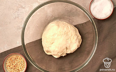 Замесите тесто. В миску влейте теплую воду, добавьте свежие прессованные дрожжи, перемешайте. Добавьте к ингредиентам соль и сахар, еще раз перемешайте. Положите в смесь сметану и сливочное масло, смешайте до однородности. Затем частями засыпайте муку, замешивая при этом тесто, которое не липнет к рукам. Когда оно будет готово, сформируйте шар, положите его в миску и накройте пищевой пленкой. Оставьте готовое тесто настаиваться на 1-2 часа.