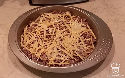 Выложите вареную гречку на дно формы для запекания, сверху посыпьте ее тертым сыром и жареным луком. Сверху положите еще один слой гречки и тертого сыра.