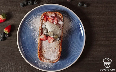 При подаче выложите на запеканку ягоды и сметану. Посыпьте сахарной пудрой.