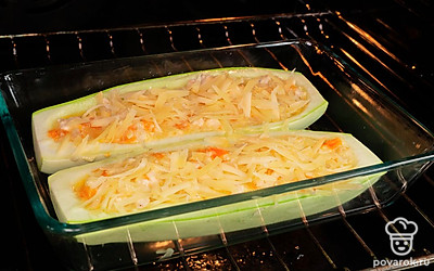 Завершите приготовление кабачков. Достаньте из духовки кабачки, наполните их начинкой. Посыпьте сверху оставшимся сыром, дайте постоять в горячей духовке 10 минут, пока сыр не расплавится.