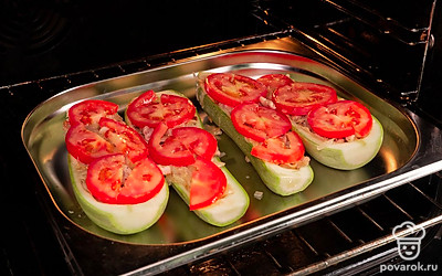 Приготовьте кабачки, фаршированные фаршем. "Лодочки" из кабачков выложите в форму для запекания, смазанную маслом. Наполните начинкой. Сверху разложите дольки помидоров. Взбейте яйцо. Смажьте помидоры сверху яичной смесью. Запекайте при 180 градусах 45-50 минут.