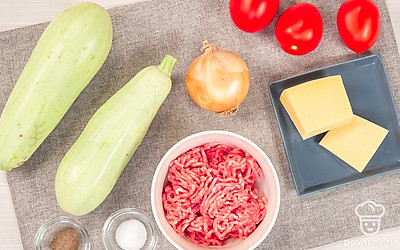 Подготовьте продукты для фарширования кабачков. Кабачки помойте. Лук почистите, измельчите. Помидоры помойте. Сыр натрите на крупной терке. Приготовьте мясной фарш. Совет: Для приготовления лучше выбирать мелкие сорта кабачков, из которых легко делать лодочки.
