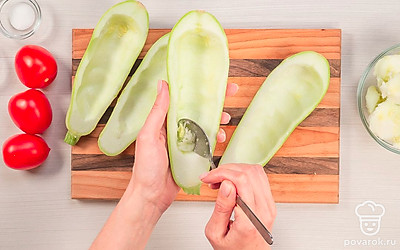 Подготовьте овощи. Кабачки разрежьте вдоль пополам и удалите ложкой семена, образовав лодочки. Помидоры нарежьте средними дольками.