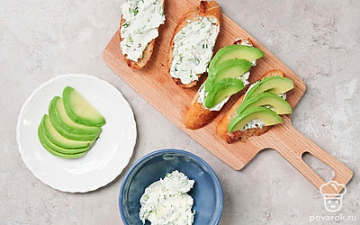 Приготовьте багет с авокадо. Соедините сливочный сыр с чесноком и зеленью. Намажьте каждый кусок этой смесью. Сверху выложите по 4 ломтика авокадо, сбрызните соком лимона, посолите по вкусу.