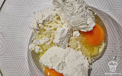 Сыр натереть на крупной терке. Смешать творог, сыр и яйца. Аккуратно перемешать. 