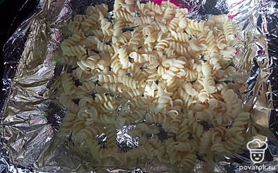 Макароны отвариваем до полуготовности, половину выкладываем в форму.