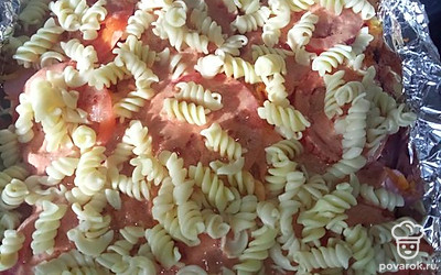 Режем помидор, выкладываем в форму, заливаем соусом и сверху выкладываем оставшиеся макароны.