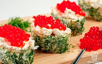 Соберите бутерброд. Верхнюю часть хлеба смажьте сливочным сыром, сверху выложите красную икру. Лимонные дольки нарежьте четвертинками, выложите их поверх икры.