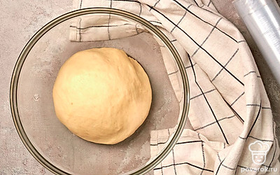 Оставьте тесто подниматься. Когда тесто станет мягким и нежным, сформируйте из него шар, после чего переложите в миску, слегка смазанную растительным маслом. Накройте его пищевой пленкой или полотенцем. Оставьте миску в теплом месте на 1 час, затем сделайте легкую обминку и оставьте еще на 1 час.