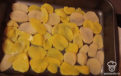 Картофель очищаем от кожуры, нарезаем на кружочки и делим на 3 части. Первую часть выкладываем на дно формы для запекания. 