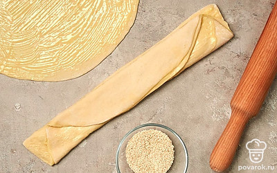 Раскатайте тесто. Обомните тесто и выложите на стол, присыпанный мукой. Разделите тесто на две части и каждую из них раскатайте в прямоугольник. Смажьте каждый прямоугольник сливочным маслом, оставив 1 ст. л. Затем сложите тесто пополам и еще раз пополам. Уберите в холодильник на 15 минут.