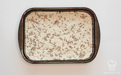 Добавьте сухофрукты в тесто и перемешайте, сверху. Смажьте форму для выпекания растительным маслом и переложите в нее заготовку. Посыпьте верху семечками. Поместите в духовку на 30 минут.