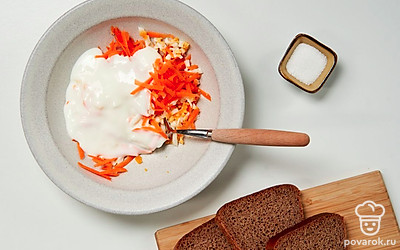 Приготовьте начинку. Соедините в емкости морковь, куриные яйца, чеснок, соль и йогурт. Хорошо перемешайте.