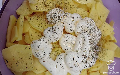 Очищаем картофель, нарезаем дольками. Солим, приправляем и смешиваем с майонезом.