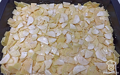 На дно противня выкладываем половину картофеля.