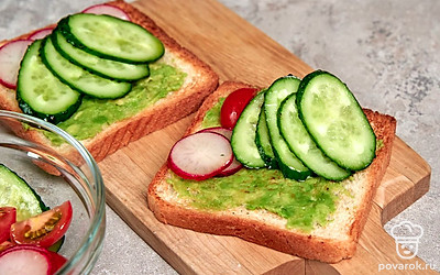 Соберите блюдо. Ломтики хлеба обильно смажьте пастой из авокадо. Далее выложите овощи. Их можно перемешать или выложить по отдельности на каждый тост, чтобы получилась разная начинка. Посыпьте блюдо перцем по вкусу.