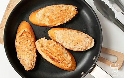 Обжарьте багет. Нагрейте растительное масло на сковороде. Выложите в масло ломтики багета пастой вниз, обжаривайте на среднем огне 2 минуты. Затем переверните и жарьте 2 минуты с другой стороны.