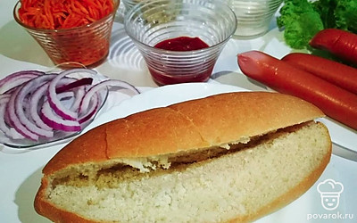 На разогретой сковороде поджарьте сосиски. Булочки надрежьте, промажьте изнутри кетчупом и майонезом, по желанию горчицей.