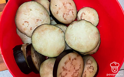 Баклажаны нарезать кружочками, засыпать солью и промыть, чтобы убрать лишнюю горечь.