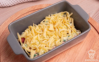 Возьмите форму для запекания, смажьте подсолнечным маслом. На дно формы положите приготовленные сосиски. Сверху хорошо присыпьте тертым сыром.