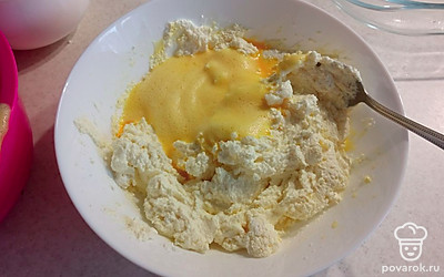 Часть яичной массы добавляем к творогу и хорошо перемешиваем.