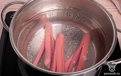 На огонь поставьте воду, как вода закипит, опустите в нее приготовленные сосиски. Солить воду не нужно, так как сосиски сами по себе достаточно посолены.