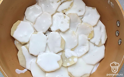 Выложите картошку на дно формы, смазанной растительным маслом. 
В отдельной емкости смешайте 4 столовых ложки сметаны и 150 миллилитров воды.
Выложенную картошку полейте заливкой.