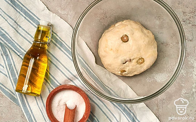 Сделайте тесто для багетов. Дрожжи разведите в небольшом количестве теплой воды. В глубокую миску всыпьте просеянную муку, добавьте соль, сахар, оливковое масло и дрожжи, разведенные в воде. Замесите тесто, добавляя воду порционно. Добавьте нарезанные оливки и хорошо вымесите тесто. Затем скатайте его в шар и накройте пищевой пленкой или полотенцем. Оставьте в теплом месте на 1,5 часа.