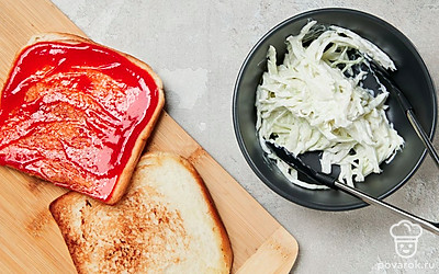 Соберите тост с капустой. Для этого в отдельной миске смешайте нашинкованную капусту и майонез. На кусочек обжаренного хлеба намажьте кетчуп и выложите капусту. Сверху положите кусочек сыра и накройте вторым ломтиком хлеба.