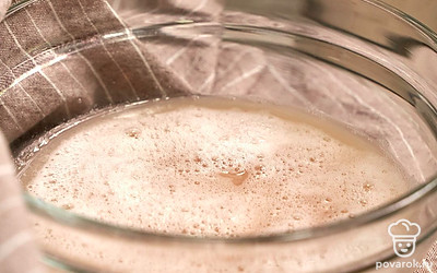 Приготовьте опару. Сухие дрожжи всыпьте в миску, добавьте сахар и 250 мл теплой воды. Перемешайте и отставьте в теплом месте на 15-20 минут до увеличения в объеме в 3 раза.