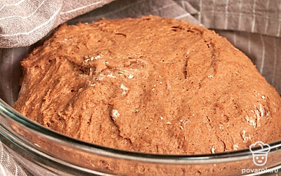 Замесите тесто. В емкости смешайте пшеничную и ржаную муку, добавьте соль и влейте поднявшиеся дрожжи и солодовую заварку. Начните замешивать тесто. В самом конце влейте растительное масло и вымесите тесто до мягкого, почти не липкого состояния. Накройте его полотенцем и оставьте в теплом месте без сквозняков на 45-50 минут. Затем обомните тесто и снова оставьте на 40-50 минут.