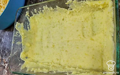 Противень смазываем подсолнечным маслом и выкладываем в него первый слой картофельного пюре. 