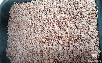 Натрите отдельно сосиски и сыр. На дно формы плотным слоем выложите гречку.