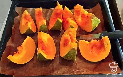 Помойте и разрежьте маленькую тыкву на куски. Выложите на противень на коврик для выпечки.